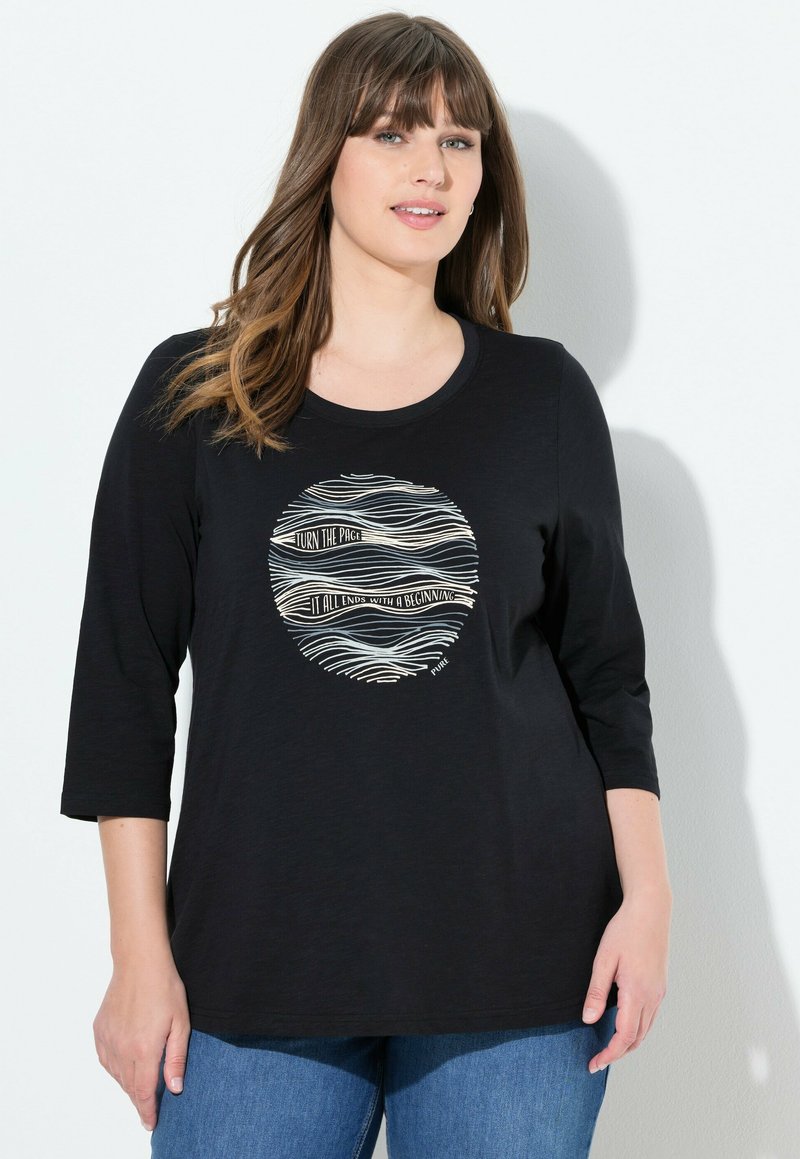 T-shirt noir à manches longues avec col rond et impression graphique mettant en avant des lignes ondulées et du texte en blanc. Tissu doux ; coupe décontractée.