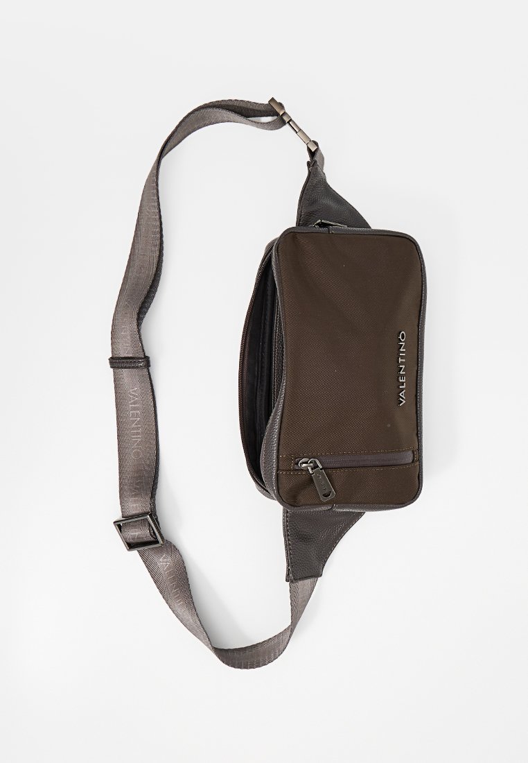 Bolso cruzado de tela marrón con acentos negros, compartimentos con cremallera y una correa ajustable que lleva el nombre de la marca "VALENTINO."