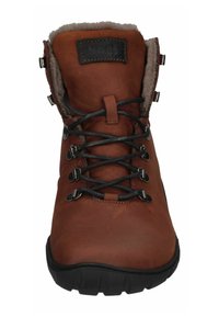 Brauner Lederstiefel mit weichem Fellfutter, schwarzen Schnürsenkeln, Metallösen und einer strukturierten schwarzen Sohle. Vertikale Naht auf der Zunge.