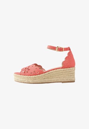 Korallrózsaszín ék talpú szandál bokapánttal, hullámos szélű, kivágott virágmintás szövet felsőrésszel és fonott juta talppal.