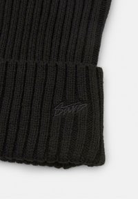 Zwarte geribbelde gebreide beanie met een zachte textuur en een omgeslagen manchet. Heeft een subtiele geborduurde logo op de manchet.