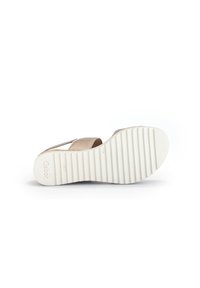 Beige sandal with a smooth upper and textured white rubber sole; features a curved design and subtle cutouts on the sides.