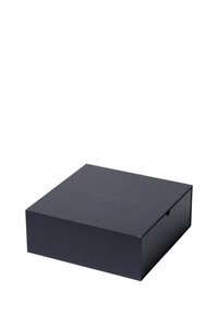 Aizvērt tumši pelēku taisnstūra kastīti ar smalki reljefām zīmola burtiem uz vāka, novietota uz balta fona.