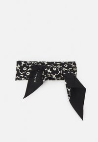 Bandeau à motif floral noir et blanc avec une finition texturée et un détail en nœud à l'avant. Le tissu est doux avec une apparence lisse.
