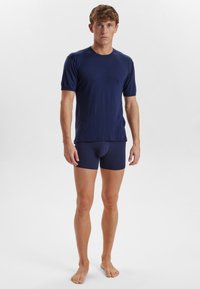 Navy blue short-sleeve shirt made of soft fabric, paired with matching fitted briefs. Simple design with a round neckline and minimal details.