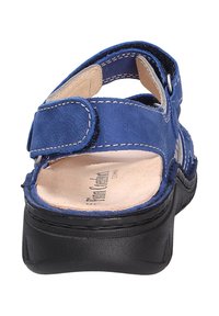 Blaue Leder-Sandale mit verstellbarem Riemen, schwarzer Sohle und leichter Innenausstattung; verfügt über kontrastierende Nähte und eine strukturierte Oberfläche.