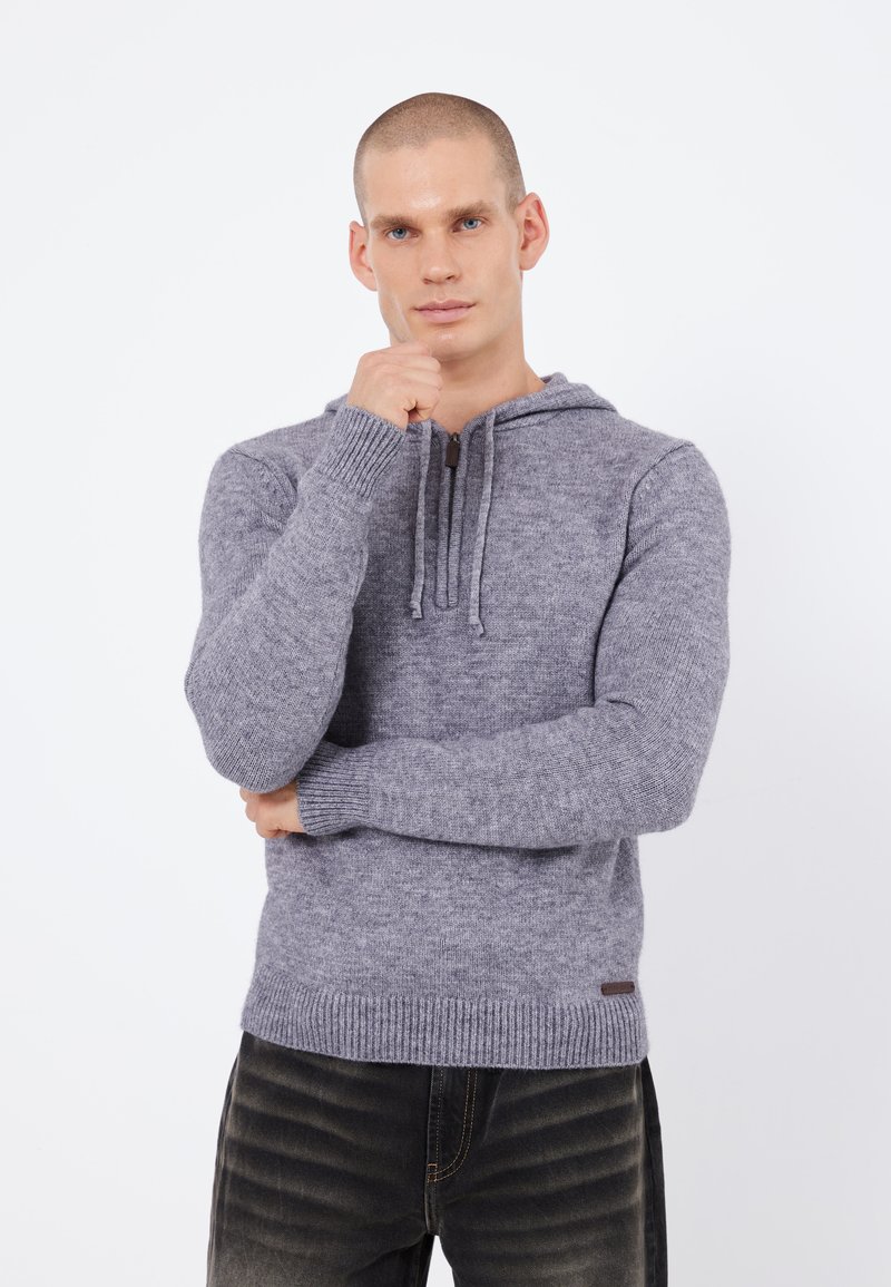 Grauer Strick-Hoodie mit Kordelzügen, gerippten Bündchen und Saum. Hergestellt aus weichem, strukturiertem Stoff, mit einem kleinen Lederlogo-Patch.