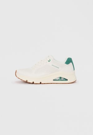 Baskets en maille blanche avec des accents verts, dotées d'un col rembourré, d'un design perforé et d'un détail en coussin d'air transparent dans la semelle.