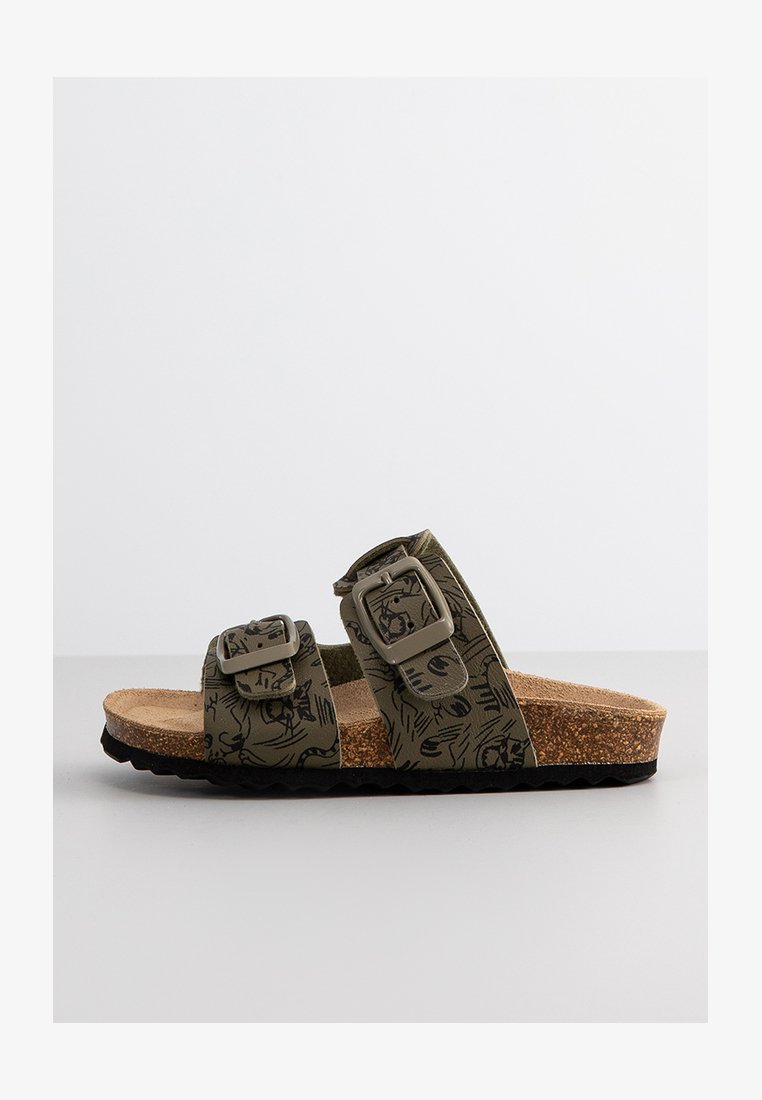 Sandalia de slide verde con estampado, dos hebillas ajustables, plantilla de corcho y suela de goma negra texturizada.