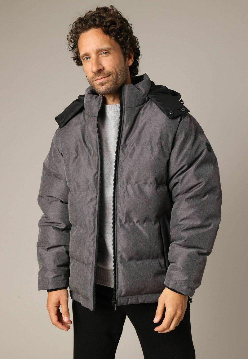 Grijze gewatteerde jas met een hoge kraag en zwarte accenten. Voorzien van een volledige rits, lange mouwen en een gladde textuur.