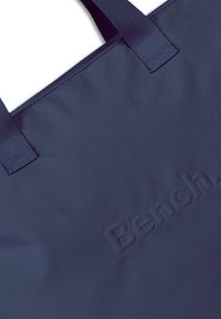 Navyblauwe draagtas gemaakt van duurzaam stof, met een geperst "Bench." logo. Stevige handvatten met versterkte stiksels voor extra sterkte.