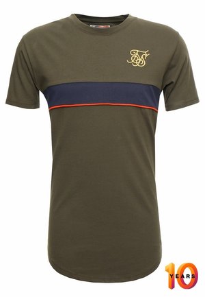 T-shirt manches courtes vert olive avec une bande horizontale bleu marine et une fine ligne rouge sur la poitrine, logo brodé en or sur la partie supérieure gauche.