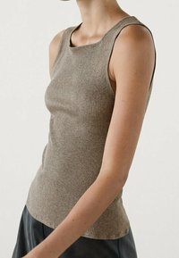 Ribbed, sleeveless top in a light brown color, featuring a square neckline and a fitted design, made from a soft, textured fabric.