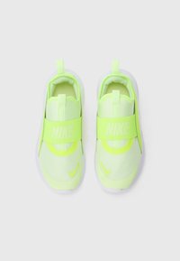 Une paire de baskets Nike à enfiler vert néon avec des bandes élastiques larges et des semelles blanches, vue de dessus sur un fond blanc.