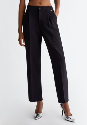 Pantaloni tailored neri con design a gamba dritta, caratterizzati da una texture liscia, chiusura con bottone singolo e un piccolo logo in evidenza.