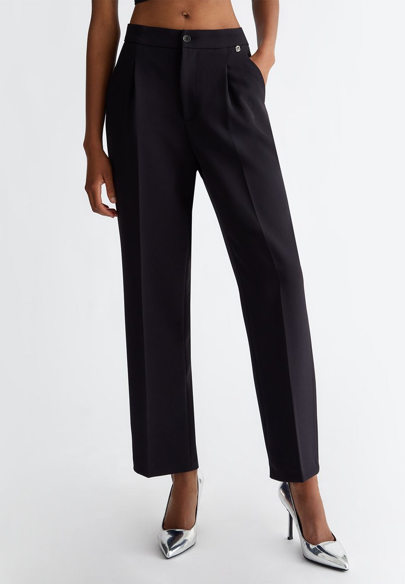 Pantaloni tailored neri con design a gamba dritta, caratterizzati da una texture liscia, chiusura con bottone singolo e un piccolo logo in evidenza.