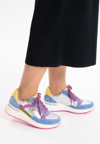 Colorful athletic shoes featuring blue suede, silver textile, and yellow accents. Thick white sole with pink detailing and purple laces.