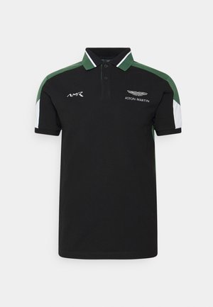 Polo nera con accenti verdi e bianchi sulle maniche, logo AMR sul petto sinistro e logo Aston Martin con testo sul petto destro.