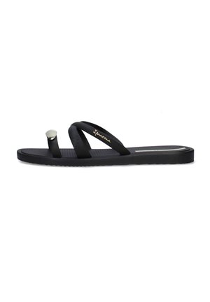 Sandalo nero piatto con anello per l'alluce e due sottili cinturini che attraversano il piede, con marchio "Ipanema" in oro su un cinturino.