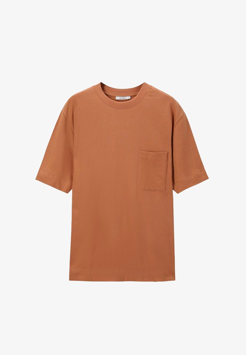 Baumwoll-T-Shirt in rostorange, mit kurzen Ärmeln und rundem Ausschnitt. Enthält eine einzelne Brusttasche für Details.