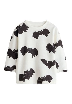 Hvid skjorte med lange ærmer med sorte tegneserieflagermus mønstre over hele stoffet, med rund halsudskæring og løs pasform.