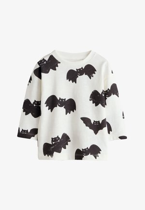 Hvid skjorte med lange ærmer med sorte tegneserieflagermus mønstre over hele stoffet, med rund halsudskæring og løs pasform.