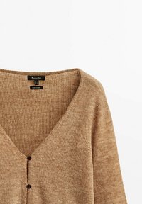 Beige gestrickter Cardigan mit tiefem V-Ausschnitt, zwei Knöpfen vorne und weichem, strukturiertem Stoff. Innen sichtbares Etikett.