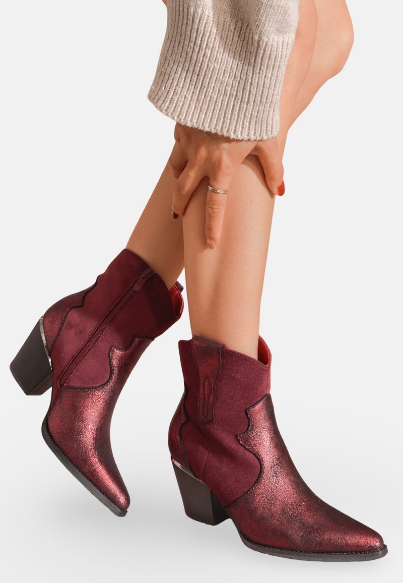 Bottines bourgogne avec une finition brillante et texturée, un bout pointu et un talon carré; fermeture éclair sur le côté et couture décorative.