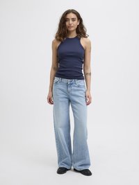 Marineblå ribbet ermeløs topp kombinert med lyseblå vide jeans, supplert med svarte flate sko. Enkelt design, uformell passform.