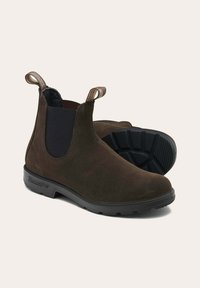 Botas de tobillo de ante marrón con paneles elásticos a los lados, tiradores para ponerlas fácilmente y suelas de goma negra texturizada para agarre y durabilidad.