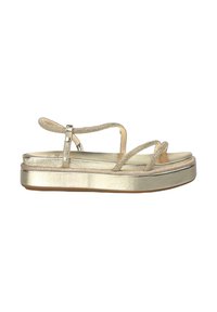 Sandales compensées dorées en métal avec des brides entrecroisées, texture lisse et semelle plate. Présente un léger éclat et une bride cheville sécurisée.
