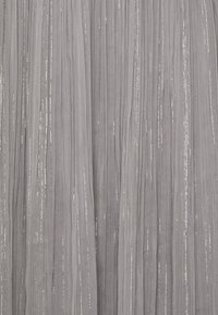Tessuto grigio con pieghe verticali e fili metallici argento. Texture morbida con una leggera lucentezza, che offre un aspetto stratificato e fluido.