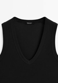 Top senza maniche nero con scollatura a V profonda. Realizzato in tessuto a coste, presenta una texture liscia e un aspetto pulito e minimalista.