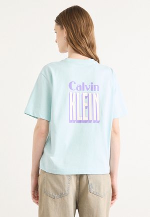 Lichtblauw T-shirt met korte mouwen van katoen, uitgerust met "Calvin KLEIN" in vet paars en witte letters op de achterkant.