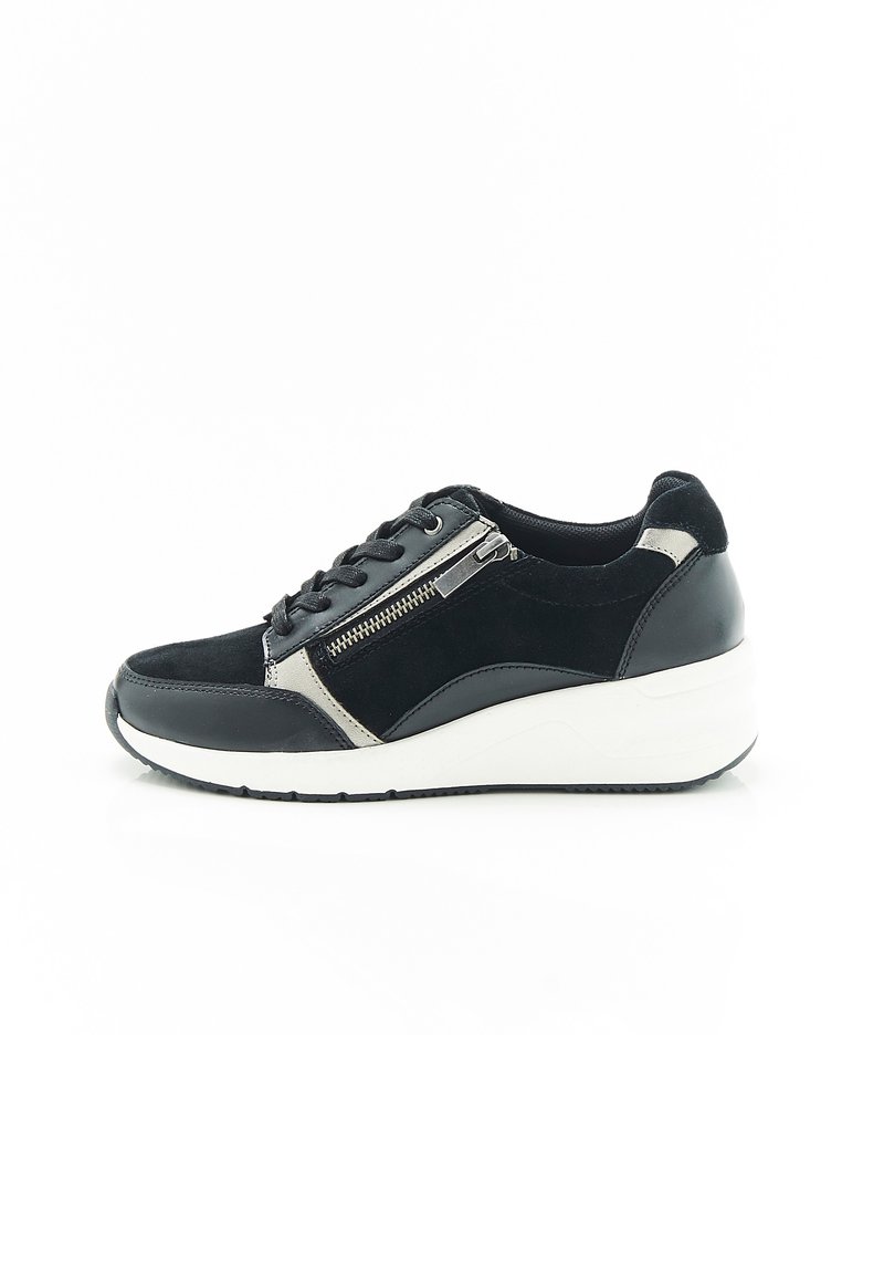 Sneaker in suede e pelle nera con suola bianca leggera, dotata di una zip laterale e dettagli metallici a contrasto. Design classico.