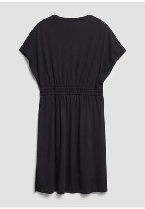 Czarna sukienka z krótkim rękawem, elastyczną talią i okrągłym dekoltem, do kolan, pokazana od tyłu na jasnym, jednolitym tle.