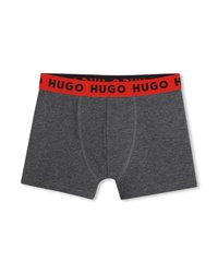 Σκούρα γκρι ανδρικά μποξεράκια με κόκκινη ελαστική ζώνη μέσης που φέρει επαναλαμβανόμενη μαύρη επιγραφή "HUGO".