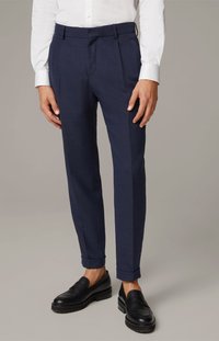 Marineblå skræddersyede bukser med et elegant design, der har frontfolder og opfoldede manchetter. Bæret med sorte slip-on sko.