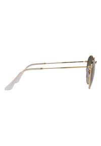 Occhiali da sole in metallo dorato con lenti scure rotonde, due sottili bracci in metallo e punte in gomma trasparente per il comfort. La montatura presenta un design elegante.