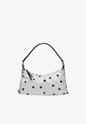 Hvid håndtaske med sorte polkaprikker, sort håndtag og sølvkædedetalje, med lynlåslukning og læder lynlås træk.