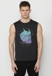 Svart ärmlös T-shirt med en grafisk dödskalledesign i teal och lila med text. Lättviktsmaterial med avslappnad passform och rund halsringning.