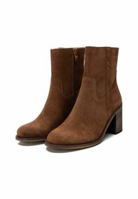 Stivaletti in suede marrone con punta arrotondata e tacco a blocco moderato, dotati di cerniera laterale e dettagli di cucitura discreti.