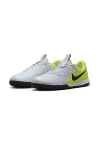 Zapatillas deportivas grises con una superficie texturizada, acentos en verde lima, logo de la marca Nike en negro y suela de goma diseñada para uso en interiores.