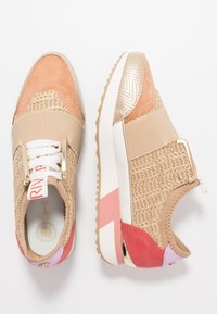 Bruna och persikofärgade sneakers med texturerad vävd ovandel, metalliska accenter och elastisk rem. Tjock vit sula med rosa och lavendelfärgade detaljer.