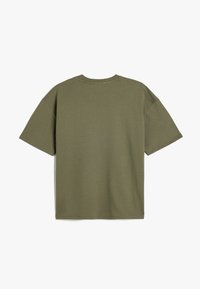 Oliivinvihreä unisex T-paita, joka on valmistettu puuvillasta. Satiin lyhyet hihat, pyöreä kaula-aukko ja rento istuvuus, jossa on sileä pinta.