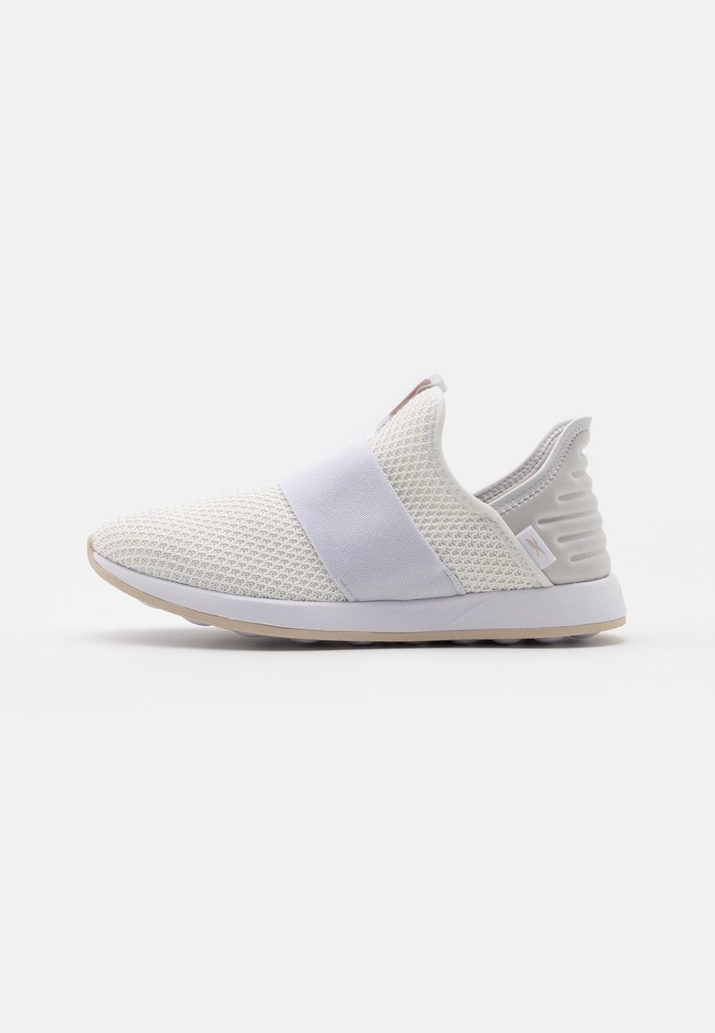 Baskets blanches à enfiler avec dessus en mesh, large bande élastique sur le dessus et contrefort de talon texturé avec semelle blanche et semelle extérieure beige.
