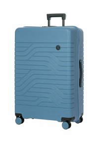 Valigia rigida di colore azzurro chiaro. Caratterizzata da eleganti motivi a onda, una maniglia retrattile e quattro ruote nere per la mobilità. Materiale resistente.