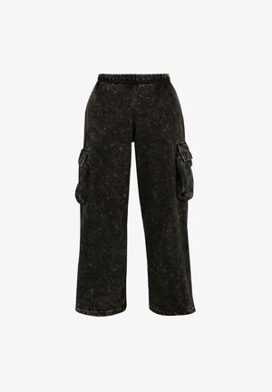 Melnas cargo bikses ar strukturētu apdari, elastīgu jostasvietu un sānu kabatām. Raksturīgas plašas kājas un brīva piegriezuma.