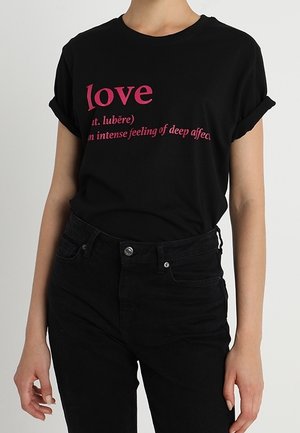 Czarny bawełniany T-shirta z podwiniętymi rękawami, z różowym napisem: "miłość" oraz jej definicją. Noszony z czarnymi dżinsami. Prosty, codzienny design.