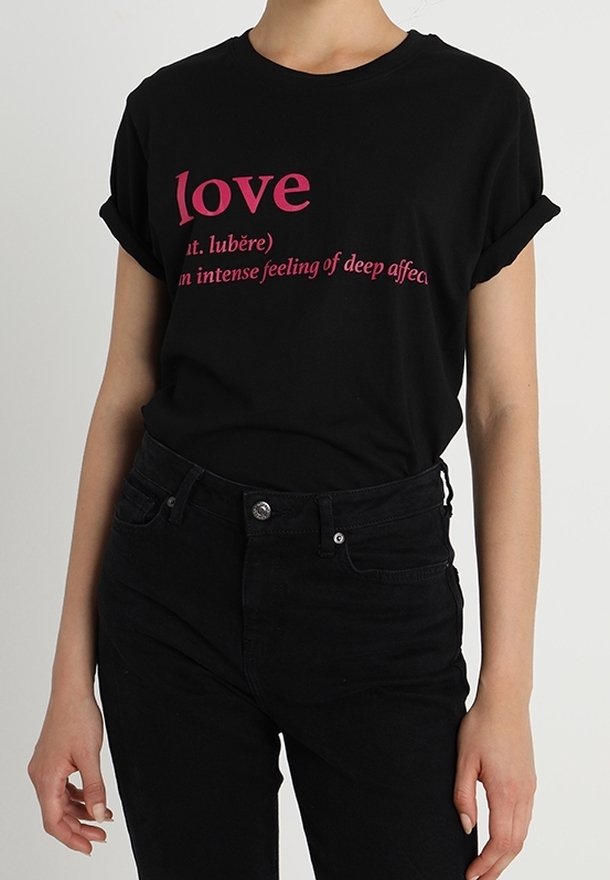 T-shirt en coton noir à manches retroussées avec du texte rose : "amour" et sa définition. Porté avec un jean noir. Design simple et décontracté.